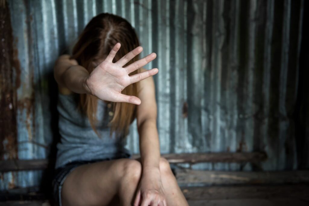 Teen girl victim of rape being frightened covering her face.